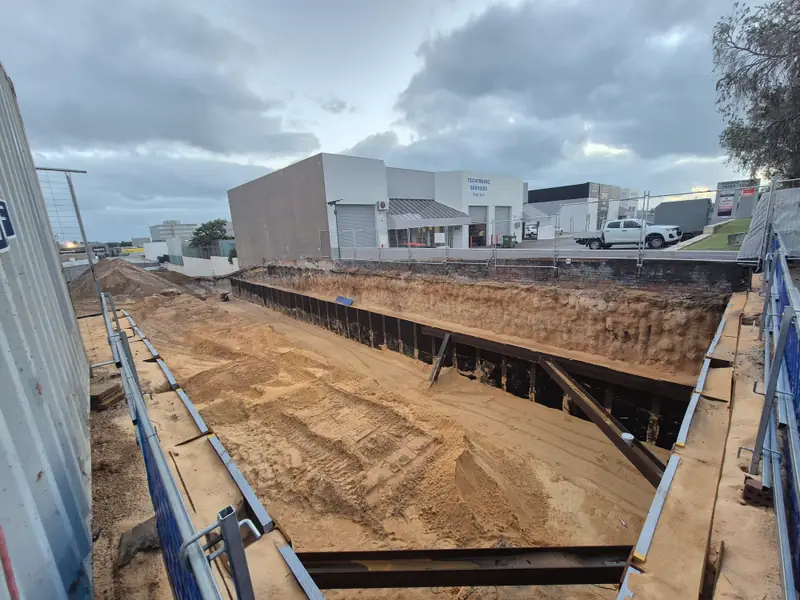 Braced commercial excavation in an industrial area, seen from the site edge